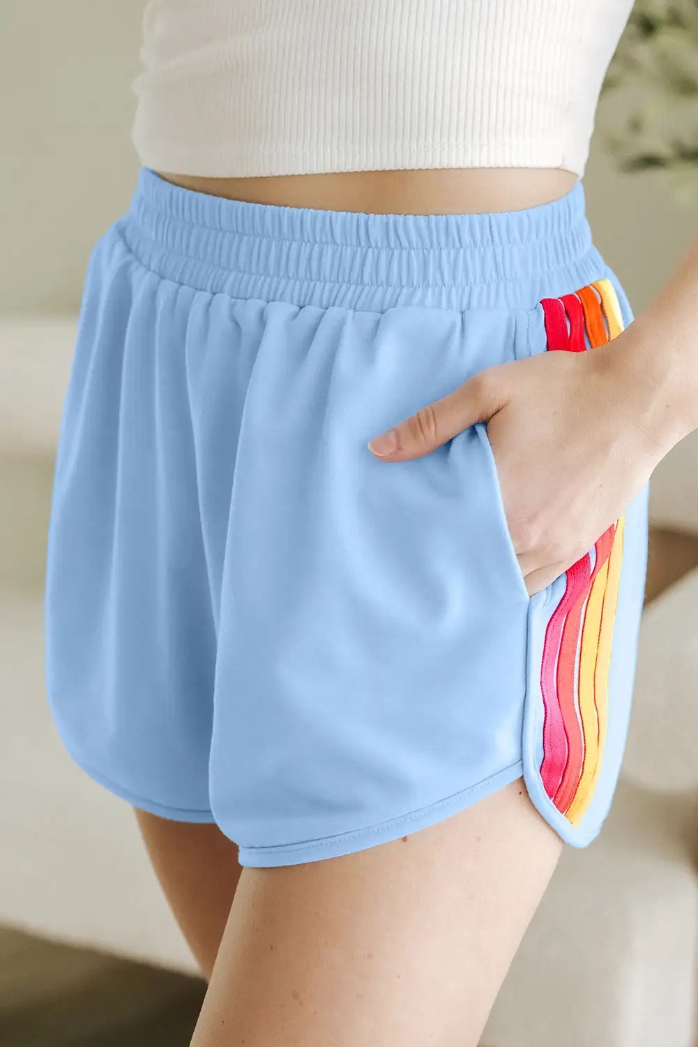 High-waist active shorts with a natural, unforced pose near a window