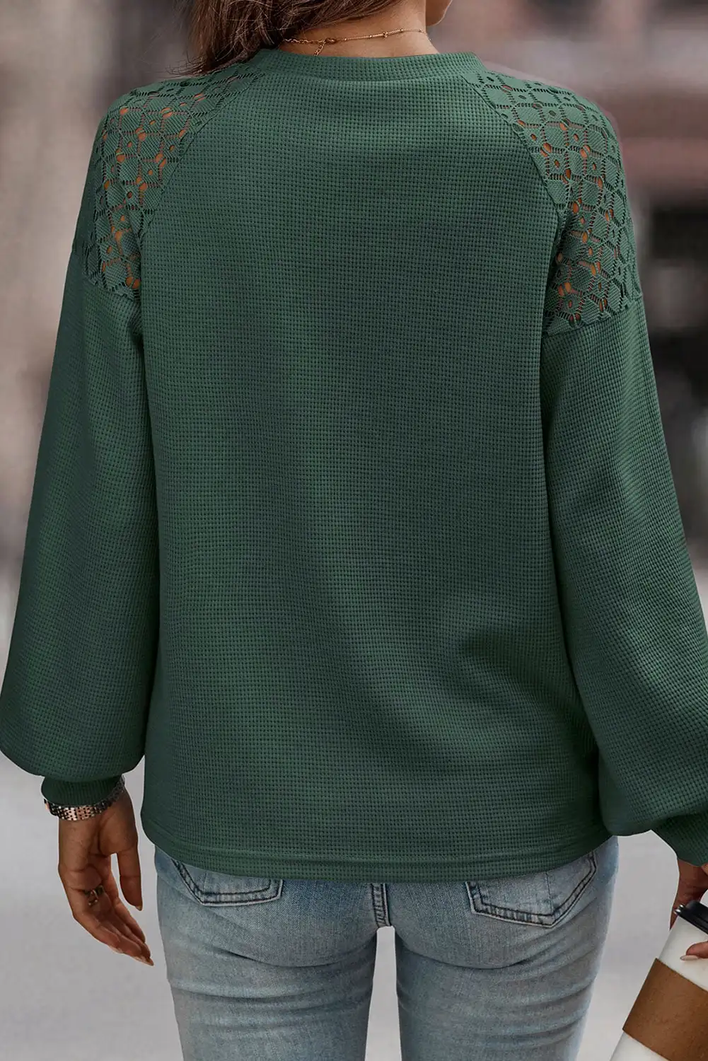 Relaxed front view of the green lace pullover in natural light